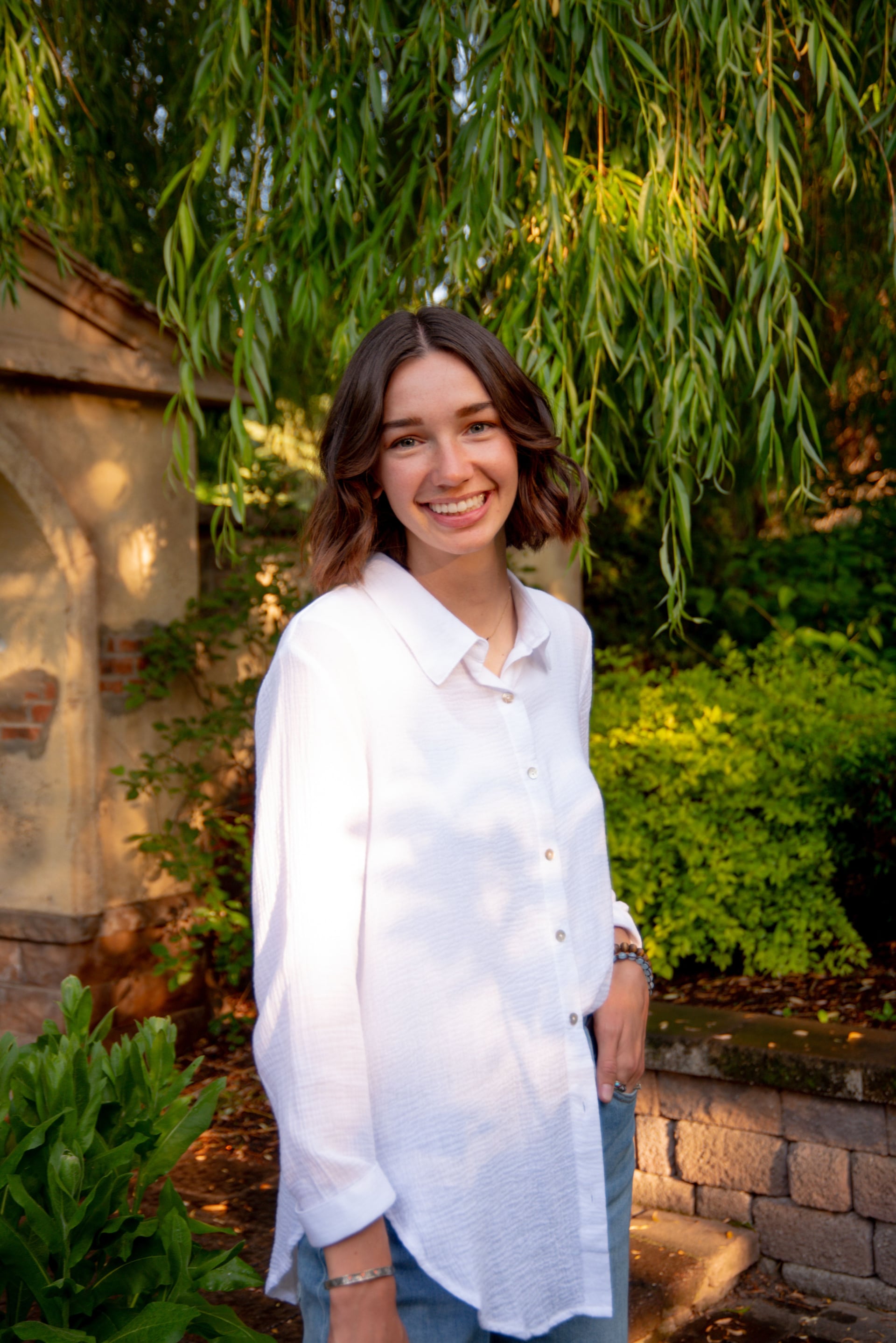 Julia Moore, professional birth filmmaker and birth doula in Northwest Arkansas, smiling in natural setting