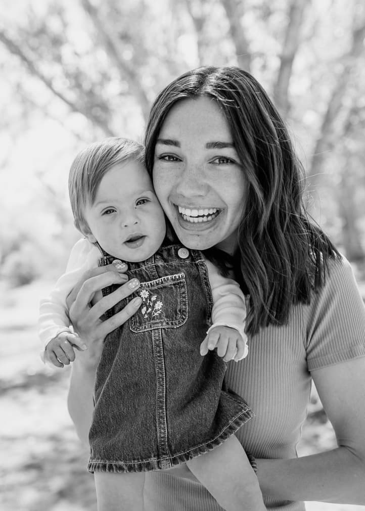 Black and white portrait of Julia Moore smiling with her baby