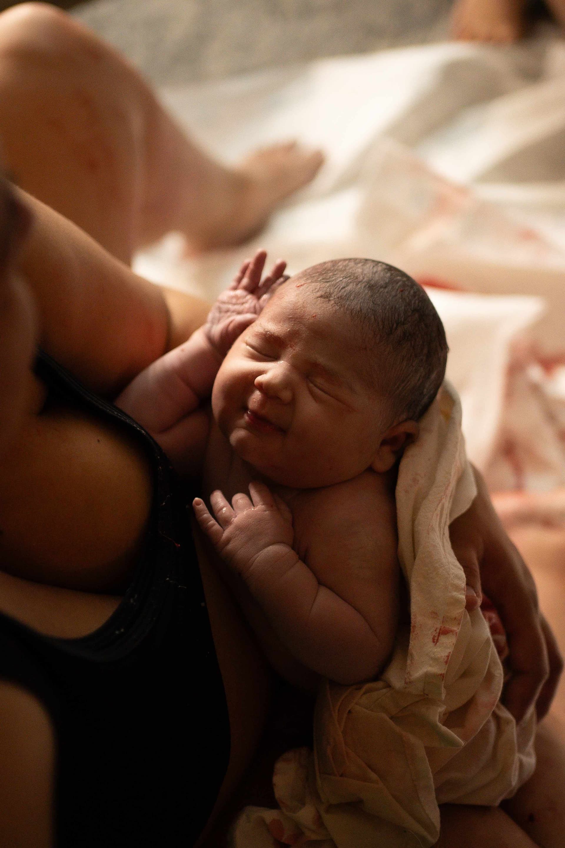 Tender first moments - newborn baby being held after birth