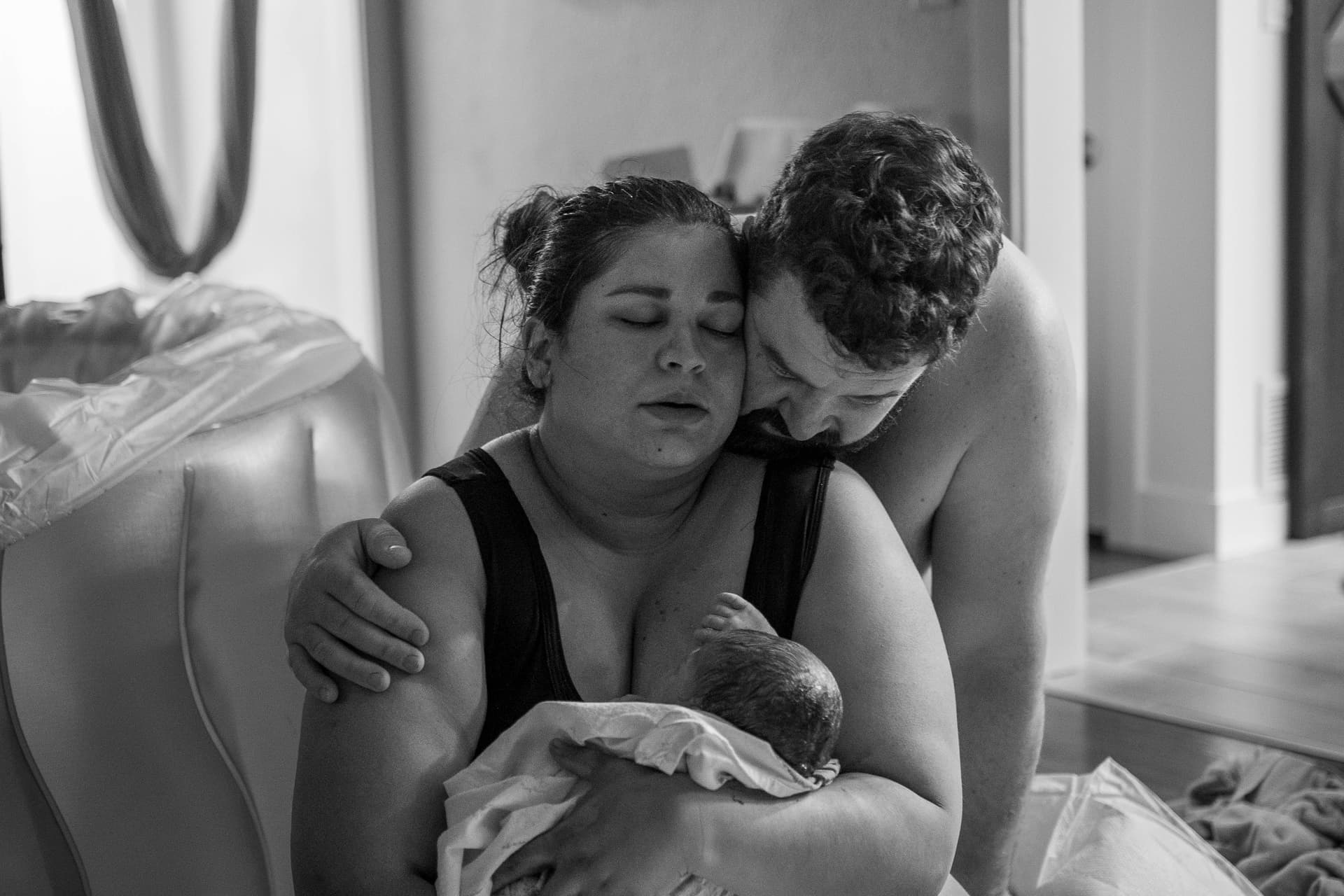 Black and white family portrait - parents with newborn